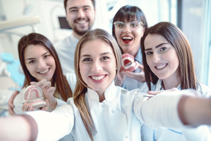 Happy-Dentists-Taking-Selfie-in-Clinic-stock-photo